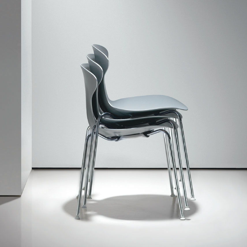 Stack of modern chairs with a minimalistic design on a white floor and light gray wall.