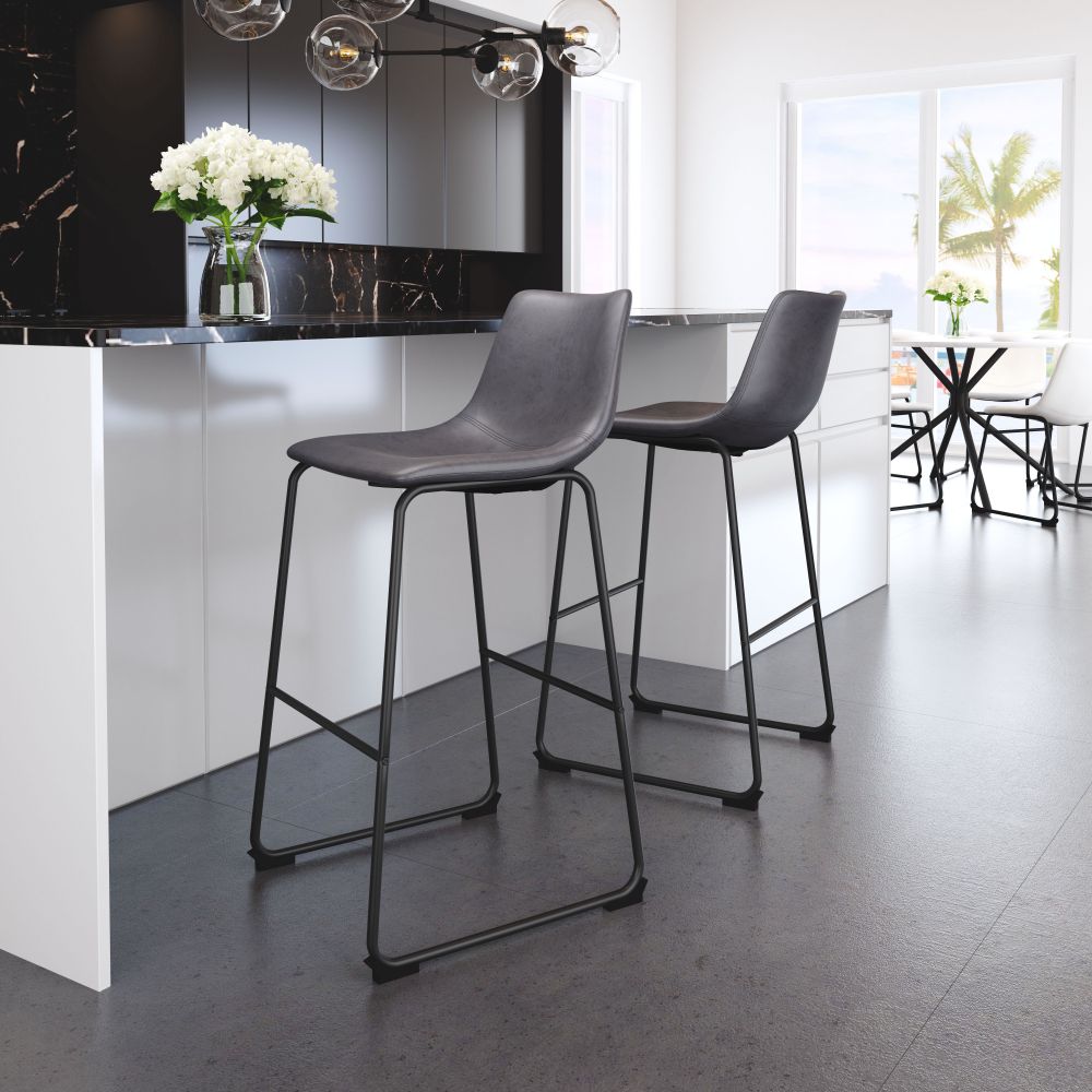 Two modern gray bar stools in a kitchen setting with a black countertop and white cabinets.
