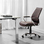 Modern office chair next to a glass desk with a white curtain background